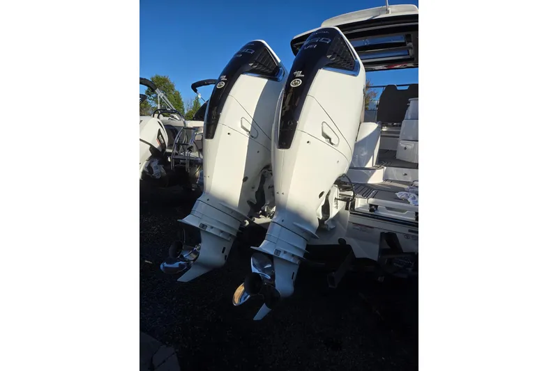 Slide: The Image of 2026 Hurricane SunDeck 3200 OB with dual outboard engines, docked under clear blue sky. - 88