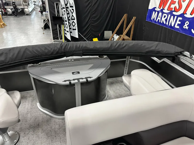 Slide: The Image of 2025 South Bay 222FCR LE boat interior with seating and console, displayed at a marine showroom. - 18