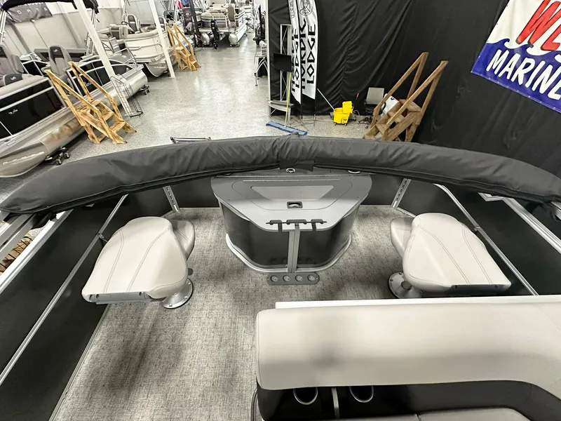 Slide: The Image of 2025 South Bay 222FCR LE pontoon boat interior with seating and console in showroom. - 19