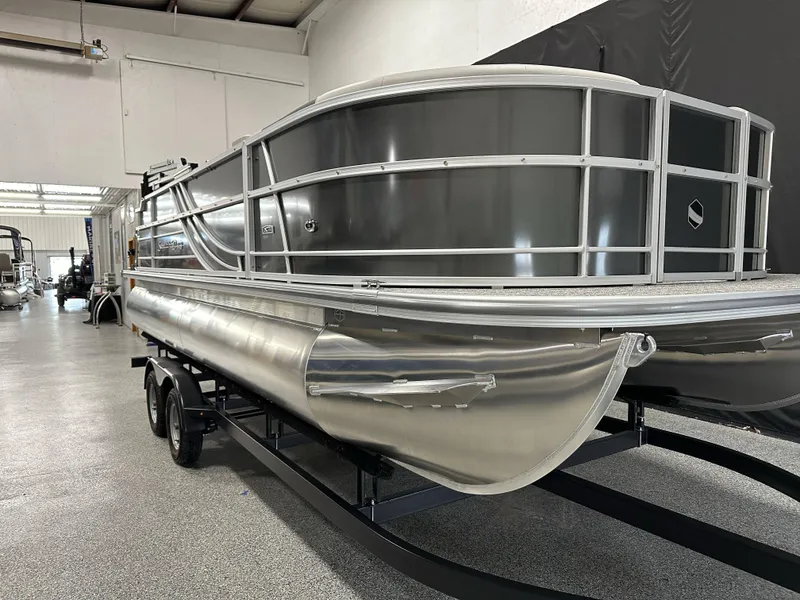 Slide: The Image of 2025 South Bay 222FCR LE pontoon boat in showroom, featuring sleek aluminum design. - 5