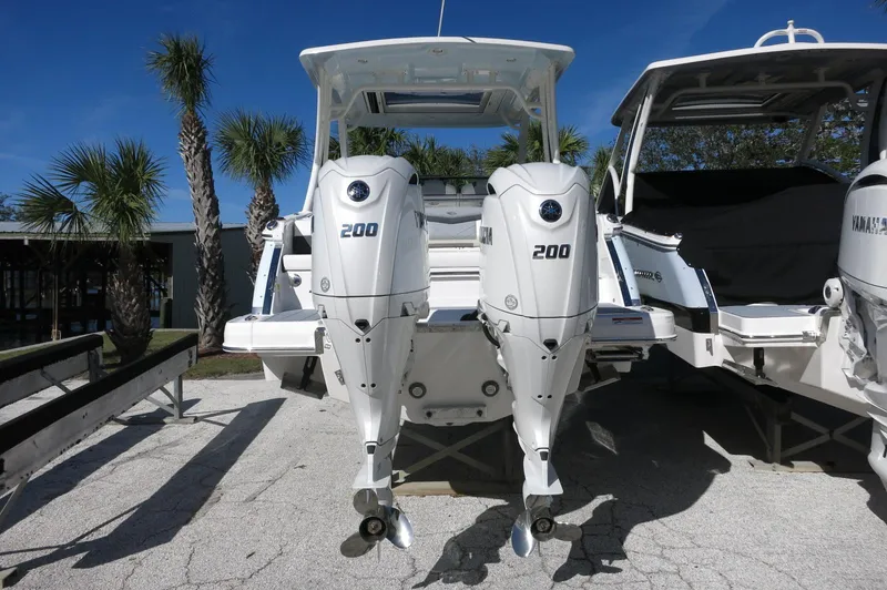 Slide: The Image of 2025 Chaparral 280 OSX Bowrider with dual 200 horsepower outboard engines, parked outdoors. - 10