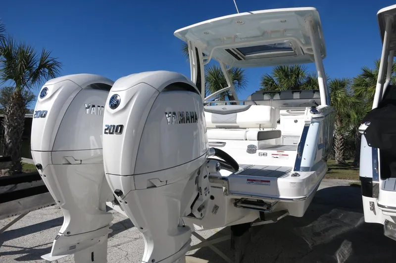 Slide: The Image of 2025 Chaparral 280 OSX Bowrider with twin Yamaha engines, parked outdoors. - 11