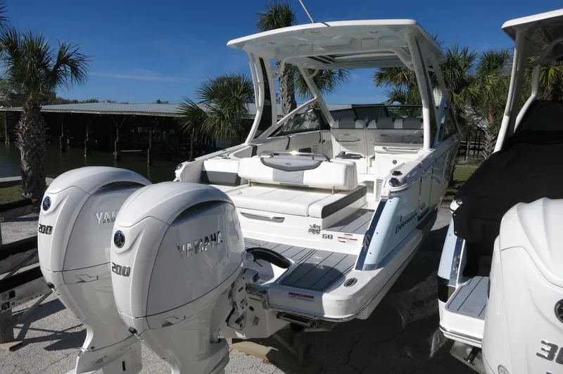 Slide: The Image of 2025 Chaparral 280 OSX Bowrider with dual Yamaha engines, parked outdoors. - 14