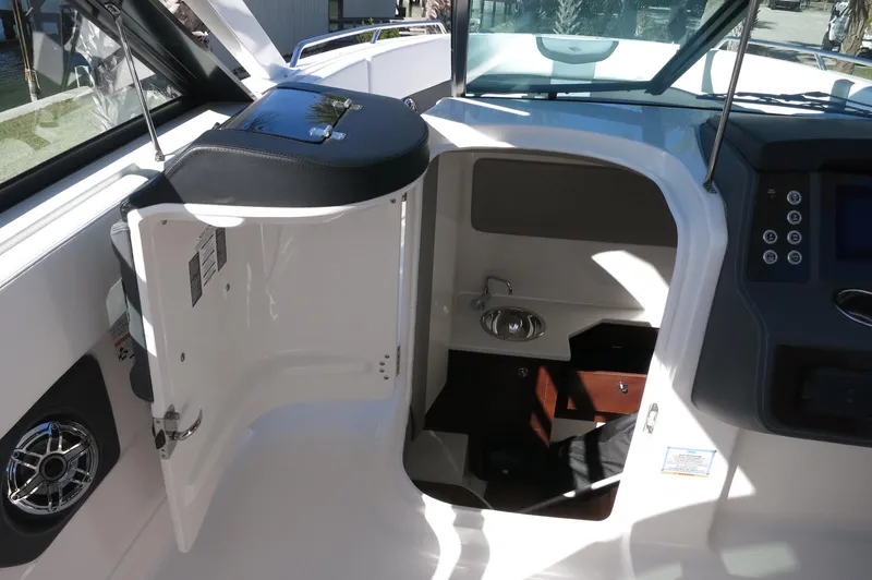 Slide: The Image of 2025 Chaparral 280 OSX Bowrider interior storage compartment with open door and sleek design. - 40
