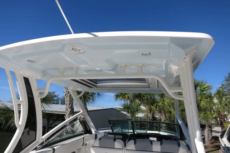 Slide: The Image of 2025 Chaparral 280 OSX Bowrider boat with sleek design and spacious seating under a clear blue sky. - 48