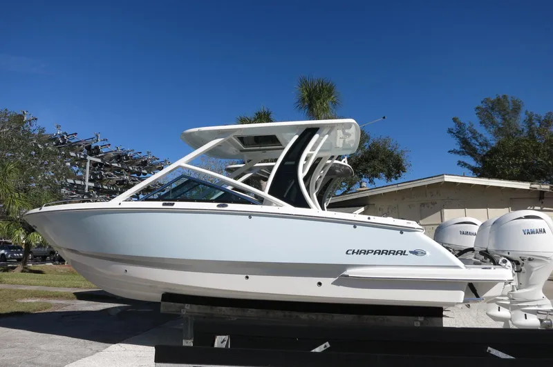 Slide: The Image of 2025 Chaparral 280 OSX Bowrider boat with sleek design, parked outdoors. - 5