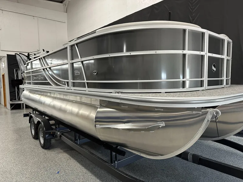 The Image of 2025 South Bay 222FCR LE 2.75 pontoon boat on trailer in showroom. - 0