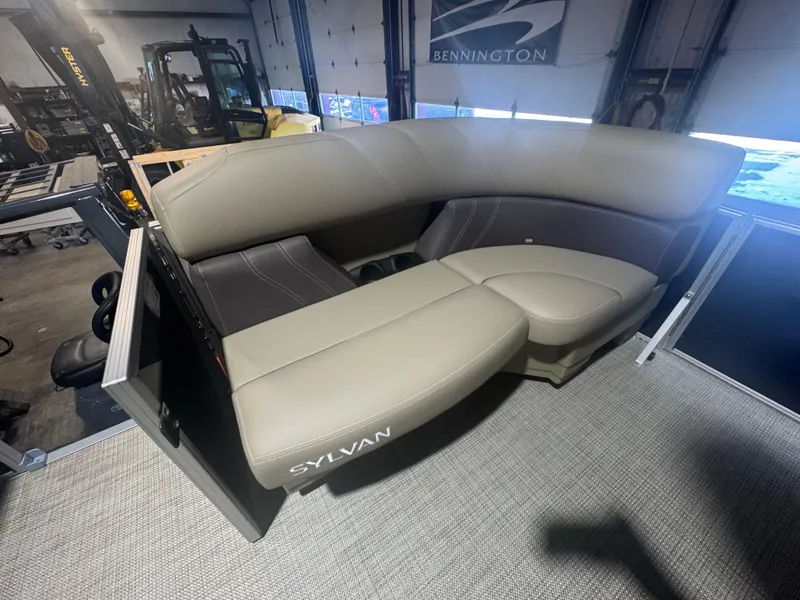 Slide: The Image of 2025 Sylvan Mirage 8520 Cruise boat interior with beige seating in a showroom. - 3
