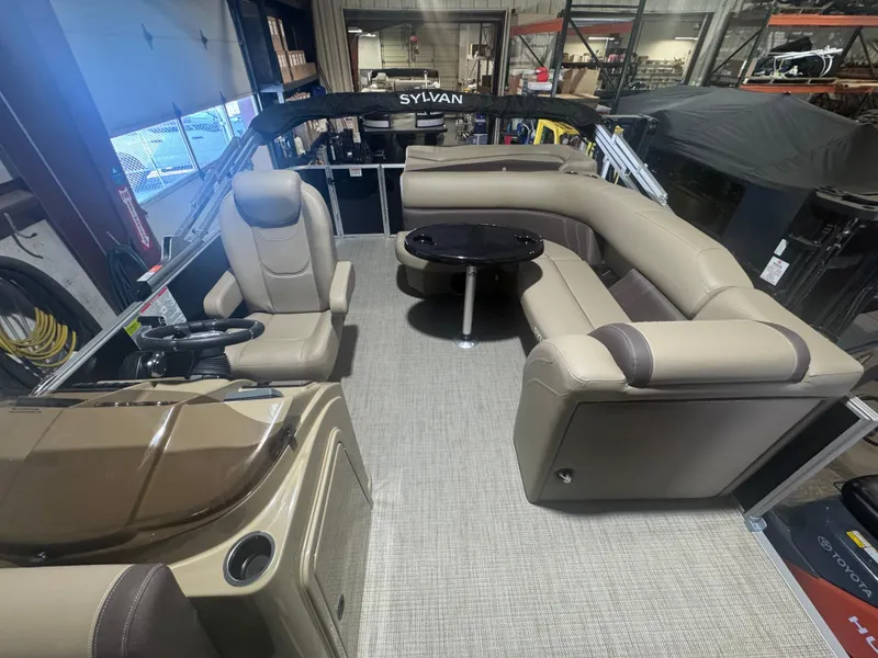 Slide: The Image of 2025 Sylvan Mirage 8520 Cruise pontoon boat interior with beige seating and steering console. - 4