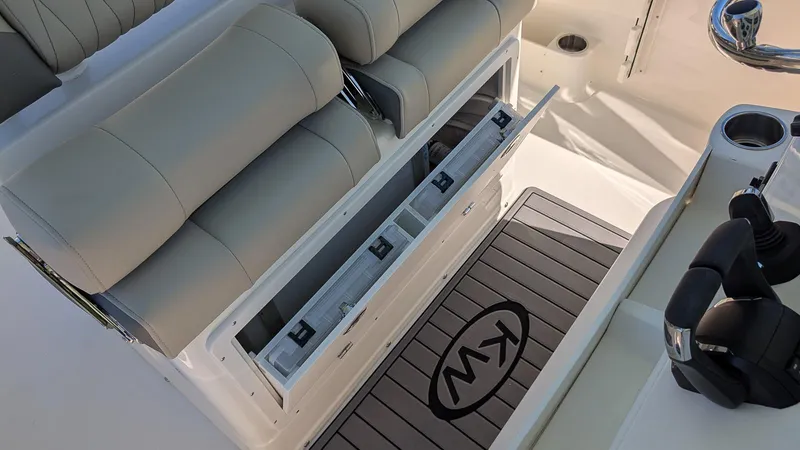 Slide: The Image of 2025 Key West 260 CC boat interior with storage compartment and cushioned seating. - 10