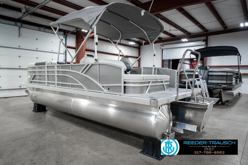 Slide: The Image of 2025 Bennington 22 SSB pontoon boat in a showroom with canopy and sleek design. - 10