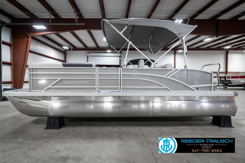 Slide: The Image of 2025 Bennington 22 SSB pontoon boat in a showroom with a canopy. - 11