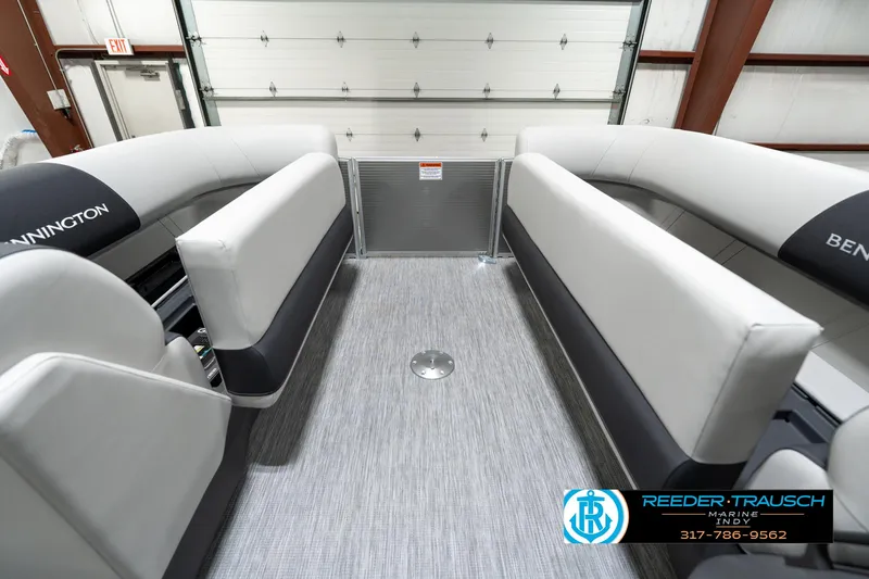 Slide: The Image of 2025 Bennington 22 SSB boat interior with gray seating and flooring in a showroom. - 23