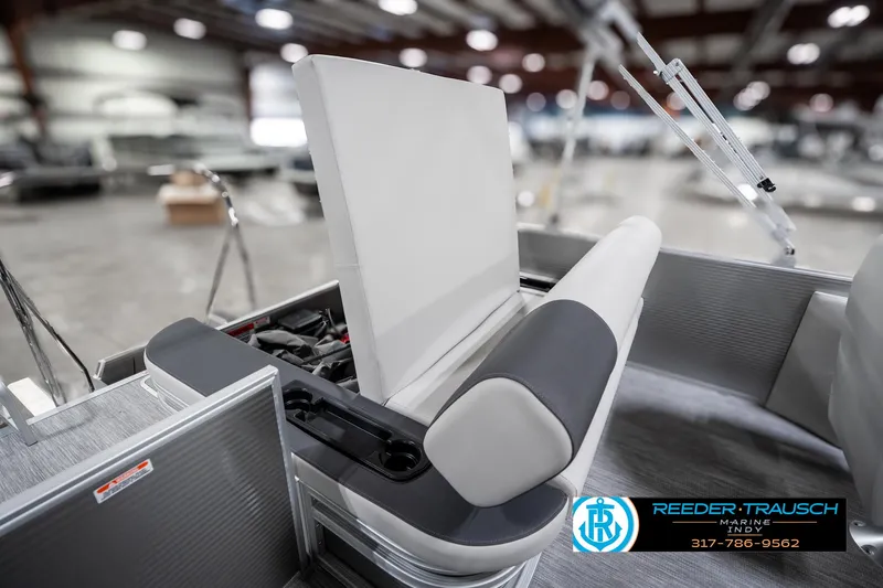 Slide: The Image of 2025 Bennington 22 SSB boat interior with seating and storage, showcased in a showroom. - 27