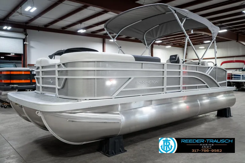 Slide: The Image of 2025 Bennington 22 SSB pontoon boat in showroom, featuring sleek design and canopy. - 3