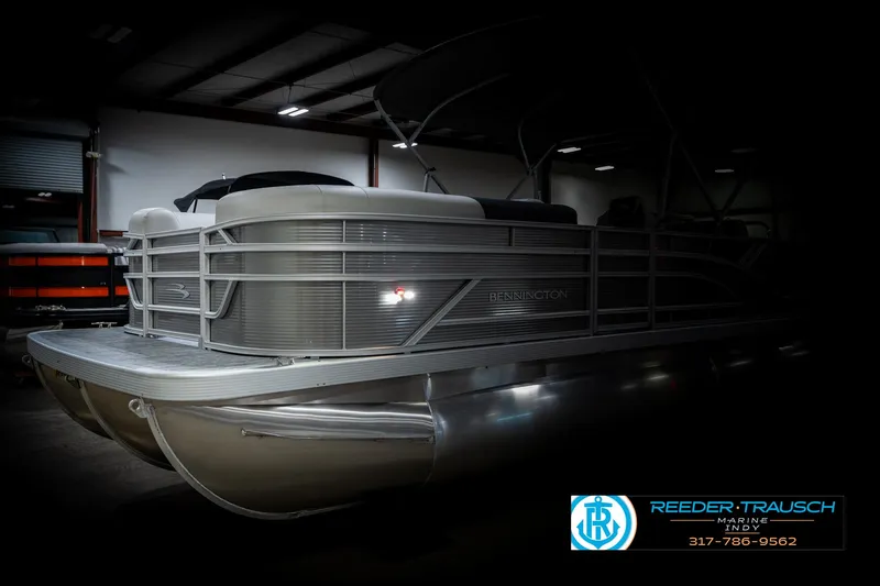 Slide: The Image of 2025 Bennington 22 SSB pontoon boat in a dimly lit indoor setting. - 4