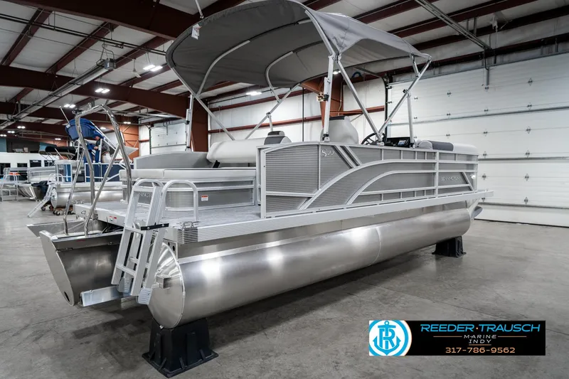 Slide: The Image of 2025 Bennington 22 SSB pontoon boat in showroom, featuring sleek design and canopy. - 8