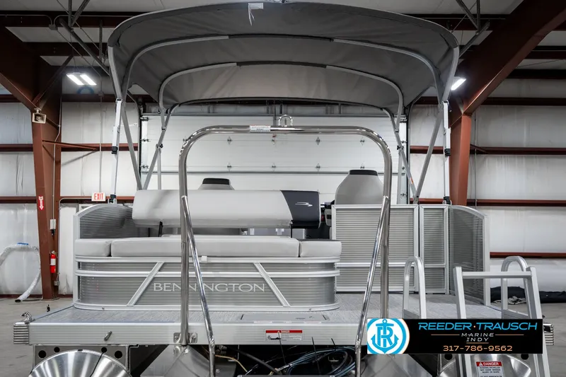Slide: The Image of 2025 Bennington 22 SSB pontoon boat with canopy in a warehouse setting. - 9