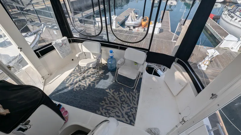 Slide: The Image of 2004 Meridian 408 Motor Yacht interior with chairs, rug, and marina view. - 11