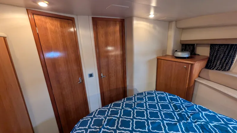 Slide: The Image of Interior of 2004 Meridian 408 Motor Yacht with wooden doors and patterned bedding. - 16