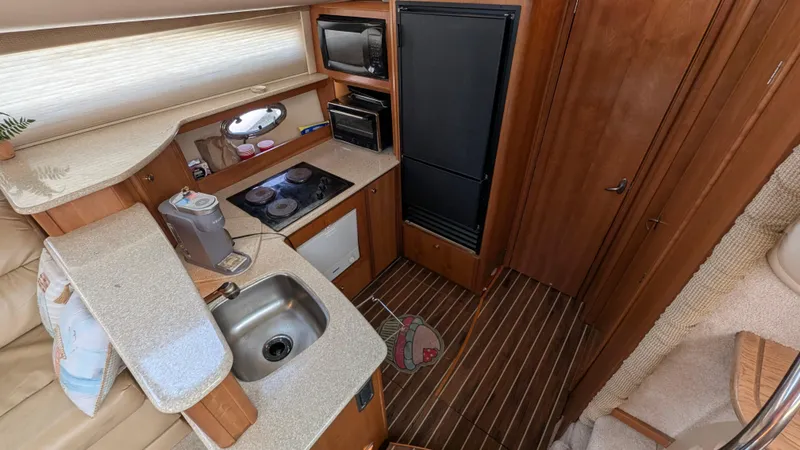 Slide: The Image of 2004 Meridian 408 Motor Yacht interior kitchen with sink, stove, and refrigerator. - 18