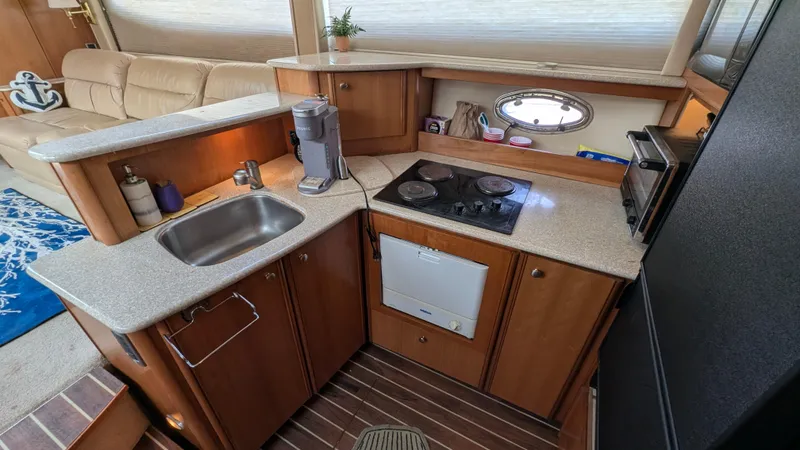 Slide: The Image of 2004 Meridian 408 Motor Yacht kitchen with sink, stove, and compact appliances. - 19