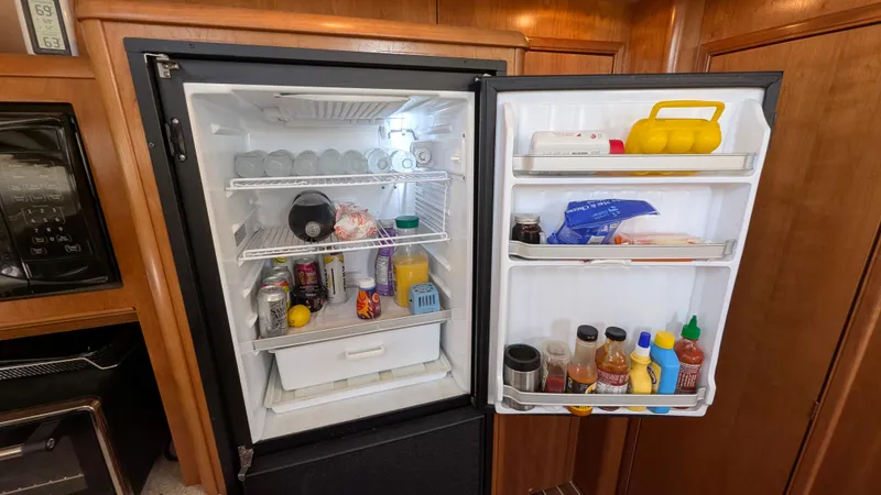 Slide: The Image of Open refrigerator in 2004 Meridian 408 Motor Yacht, stocked with various food and beverages. - 21