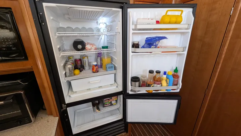 Slide: The Image of Open refrigerator in 2004 Meridian 408 Motor Yacht, stocked with various food and beverages. - 22