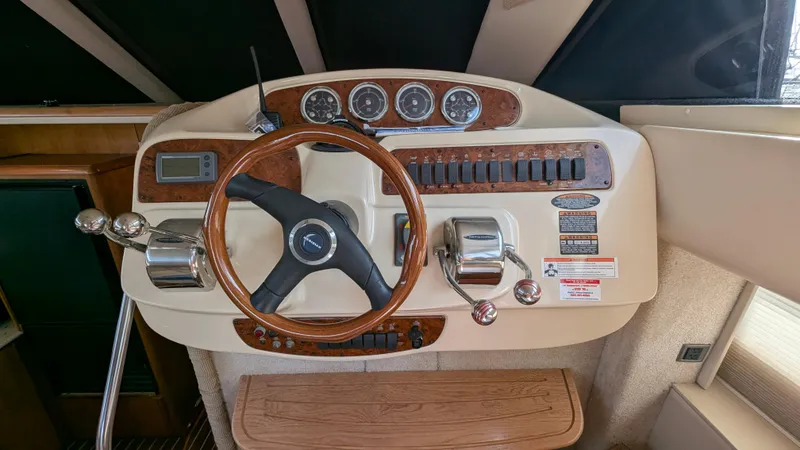 Slide: The Image of 2004 Meridian 408 Motor Yacht helm with wooden steering wheel and control panel. - 26