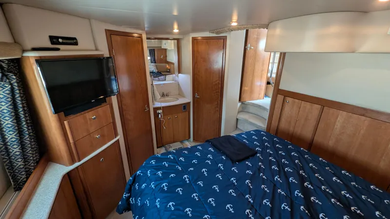 Slide: The Image of 2004 Meridian 408 Motor Yacht interior with bed, TV, and wooden cabinetry. - 40