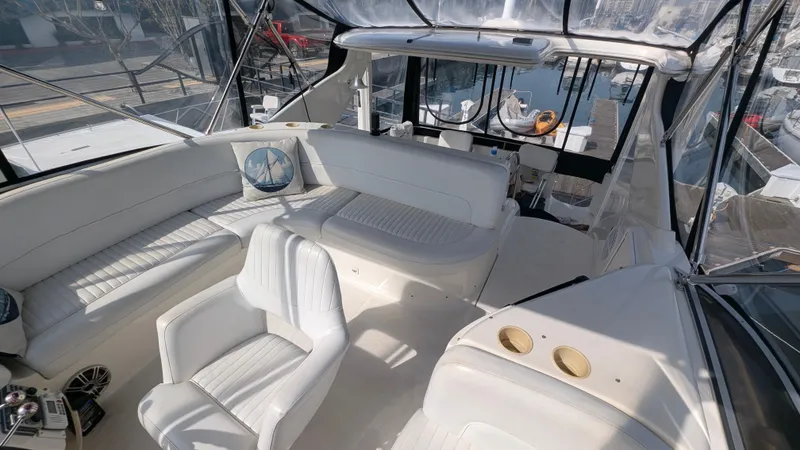 Slide: The Image of 2004 Meridian 408 Motor Yacht interior with white seating and helm, docked at marina. - 8
