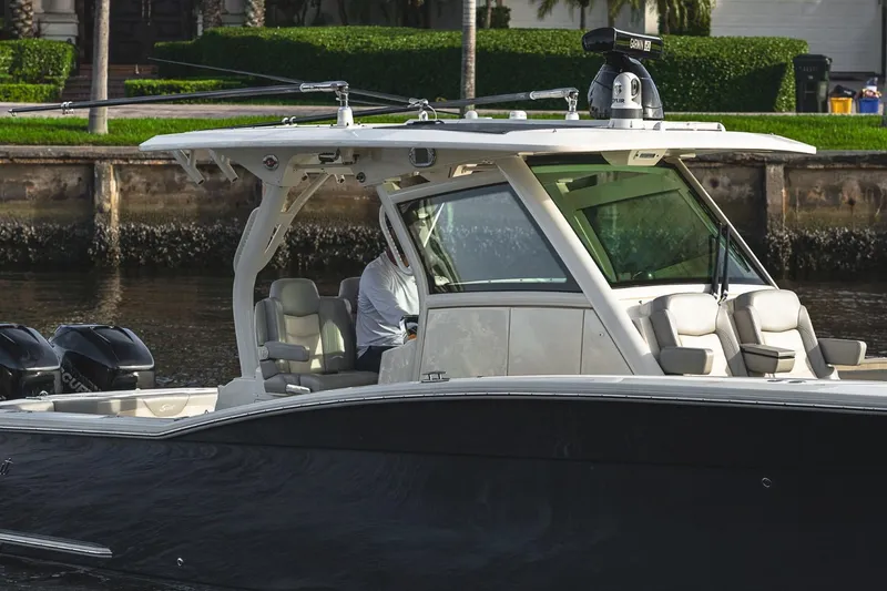 Slide: The Image of 2021 Scout 355 LXF boat cruising on a calm waterway. - 13