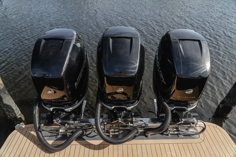 Slide: The Image of Triple outboard engines on a 2021 Scout 355 LXF boat, docked on water. - 18