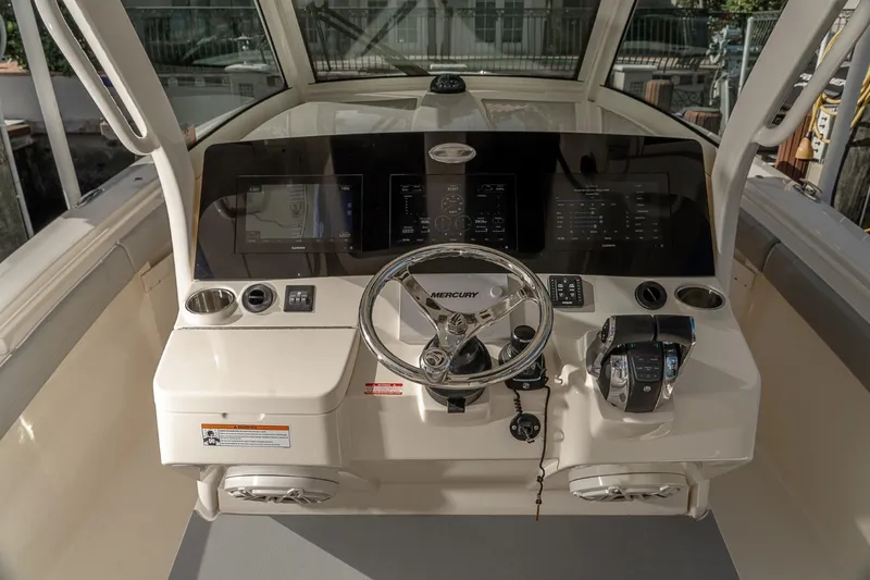 Slide: The Image of 2021 Scout 355 LXF boat helm with steering wheel and control panel. - 19