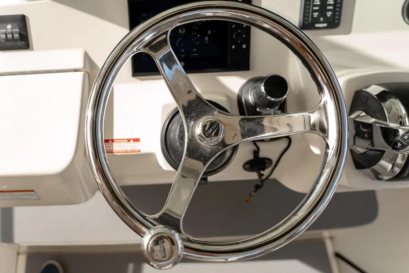Slide: The Image of Steering wheel of 2021 Scout 355 LXF boat, featuring modern controls and dashboard. - 27