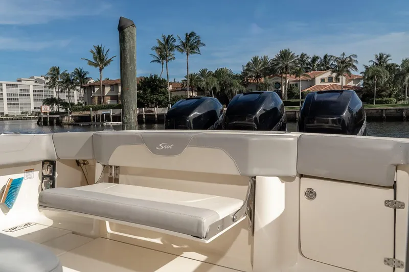 Slide: The Image of 2021 Scout 355 LXF boat with triple engines docked near palm trees. - 35