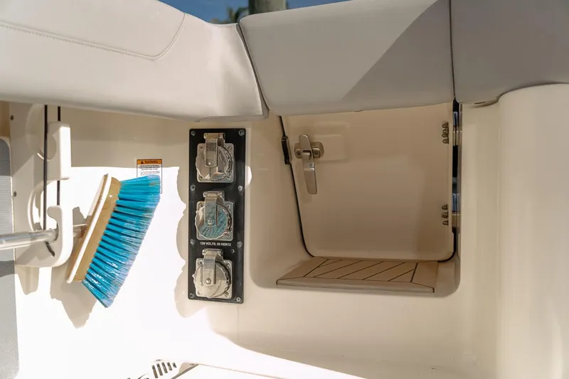 Slide: The Image of 2021 Scout 355 LXF boat interior with storage compartment and cleaning brush. - 36