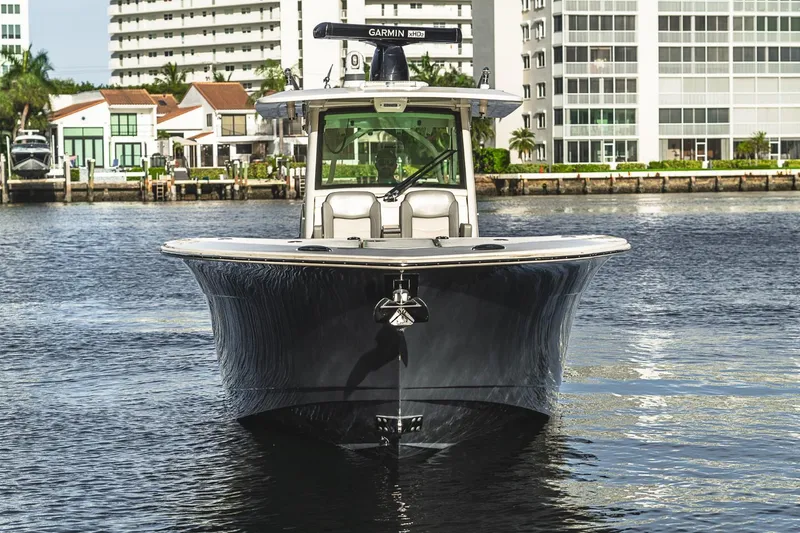 Slide: The Image of 2021 Scout 355 LXF boat on water, cityscape background, front view. - 4