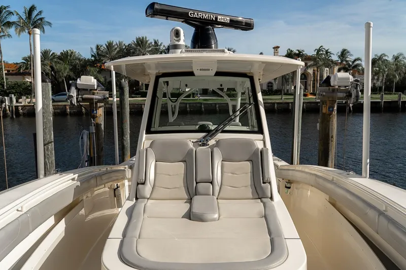 Slide: The Image of 2021 Scout 355 LXF boat with luxurious seating and Garmin equipment, docked by the water. - 46