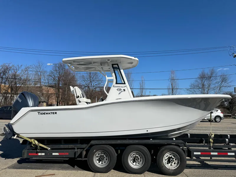 The Image of 2025 Tidewater 232 CC Adventure boat on trailer, side view, clear blue sky. - 0