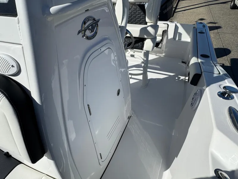 Slide: The Image of 2025 Tidewater 232 CC Adventure boat interior with white console and seating. - 11