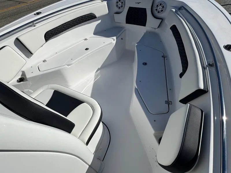 Slide: The Image of 2025 Tidewater 232 CC Adventure boat interior with white and black seating. - 8