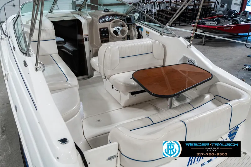 Slide: The Image of 2000 Chaparral Signature 240 boat interior with white seating and wooden table. - 14
