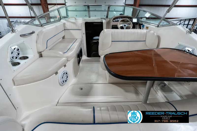 Slide: The Image of 2000 Chaparral Signature 240 boat interior with seating and table, featuring a steering wheel. - 15
