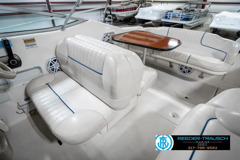 Slide: The Image of Interior of 2000 Chaparral Signature 240 boat with white seating and wooden table. - 21