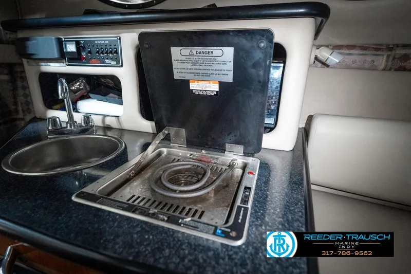 Slide: The Image of 2000 Chaparral Signature 240 boat interior with stove and sink in compact kitchen area. - 31