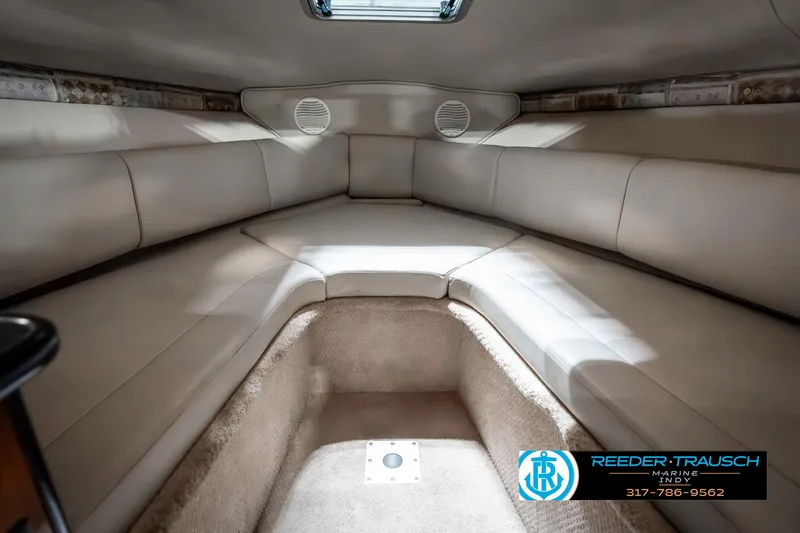 Slide: The Image of Interior cabin of 2000 Chaparral Signature 240 boat, featuring cushioned seating and carpeted flooring. - 33