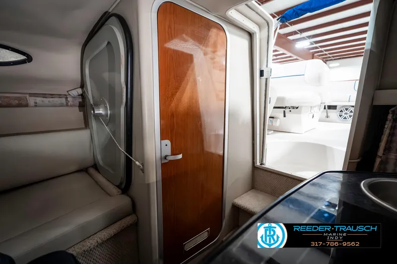 Slide: The Image of Interior view of a 2000 Chaparral Signature 240 boat, featuring a wooden cabin door. - 35