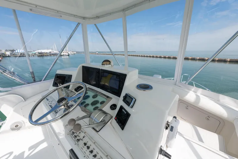 Slide: The Image of Helm of 2000 Cabo Convertible yacht with ocean view and navigational instruments. - 10