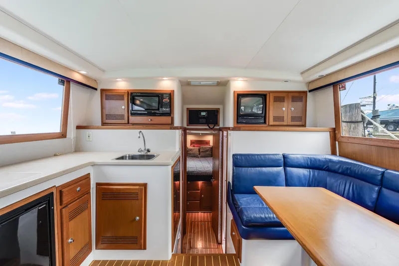 Slide: The Image of Interior of a 2000 Cabo Convertible boat with kitchen and seating area. - 14